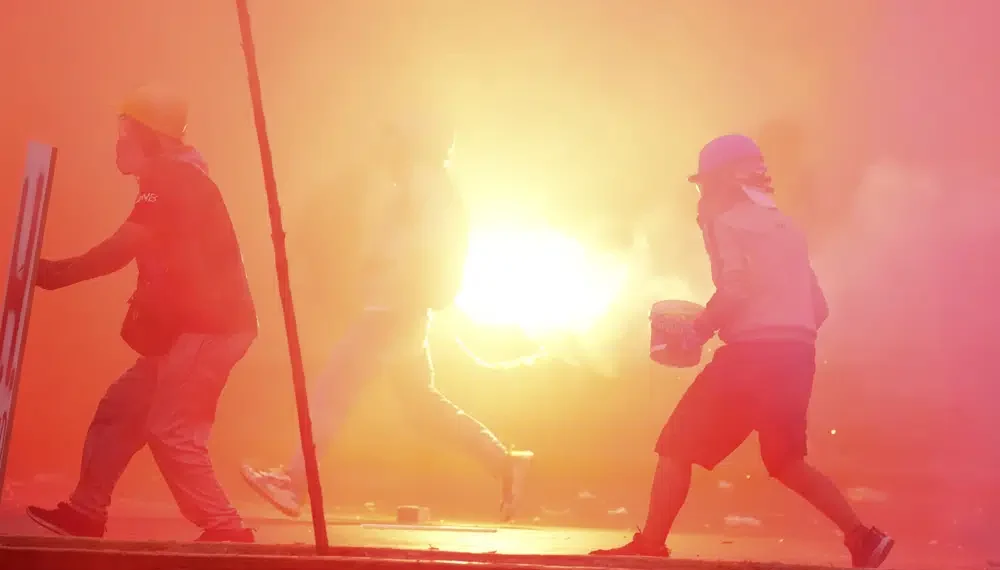 Peru’s protest ‘deactivators’ run toward tear gas to stop it